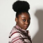 Portrait Photo of Woman Standing in Front of White Wall